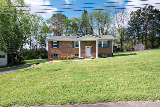 971 Hamilton Cir NW, Cleveland, TN 37312 - raised ranch featuring brick siding, a front lawn, metal roof, and an outbuilding