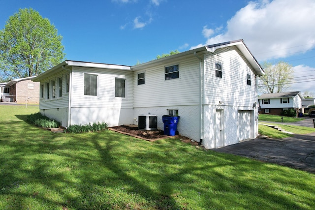 971 Hamilton Cir NW, Cleveland, TN 37312 - back of house featuring asphalt driveway, a garage, central AC unit, and a lawn
