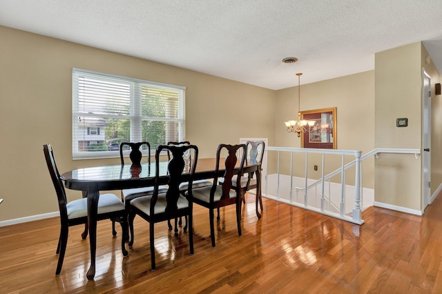 971 Hamilton Cir NW, Cleveland, TN 37312 - dining space featuring a chandelier, wood finished floors, baseboards, and a textured ceiling