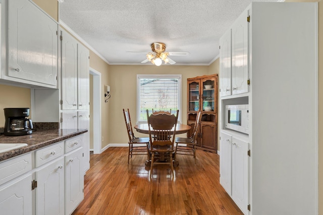 971 Hamilton Cir NW, Cleveland, TN 37312 - dining room with ceiling fan, crown molding, a textured ceiling, light wood-type flooring, and baseboards