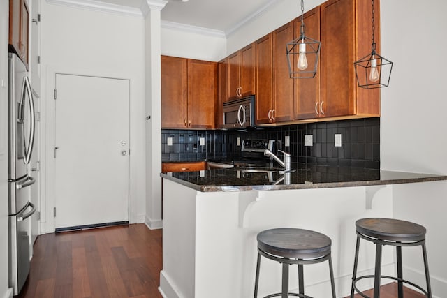 129 Walnut St Unit 212, Chattanooga, TN 37403 - kitchen featuring appliances with stainless steel finishes, crown molding, a peninsula, backsplash, and dark wood-type flooring