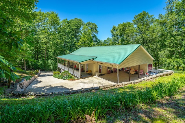 375 Cody Way, Tunnel Hill, GA 30755 - rear view of house featuring metal roof, concrete driveway, covered porch, and a carport