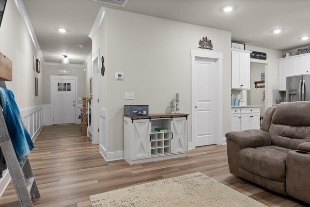7559 Snow Cone Way, Ooltewah, TN 37363 - living area featuring light wood finished floors, crown molding, recessed lighting, and a wainscoted wall