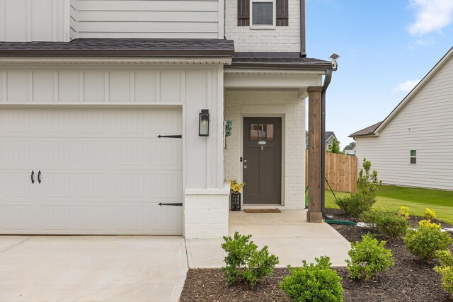 7559 Snow Cone Way, Ooltewah, TN 37363 - property entrance with brick siding, board and batten siding, an attached garage, concrete driveway, and roof with shingles