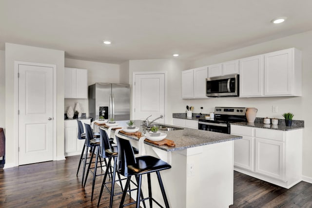300 Draft St, Rossville, GA 30741 - kitchen with stainless steel appliances, a sink, dark wood-style floors, a center island with sink, and stone counters