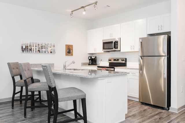 804 Riverfront Pkwy Unit 307, Chattanooga, TN 37402 - kitchen featuring stainless steel appliances, a sink, a breakfast bar, and white cabinetry