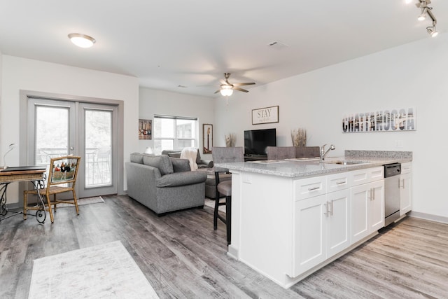 804 Riverfront Pkwy Unit 307, Chattanooga, TN 37402 - kitchen featuring a sink, stainless steel dishwasher, white cabinetry, a peninsula, and light wood-style floors