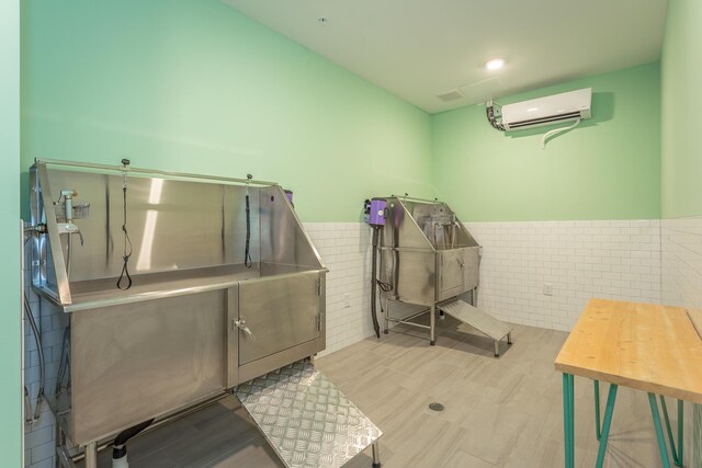 804 Riverfront Pkwy Unit 307, Chattanooga, TN 37402 - misc room with pet washing station, a wall unit AC, tile walls, wainscoting, and recessed lighting