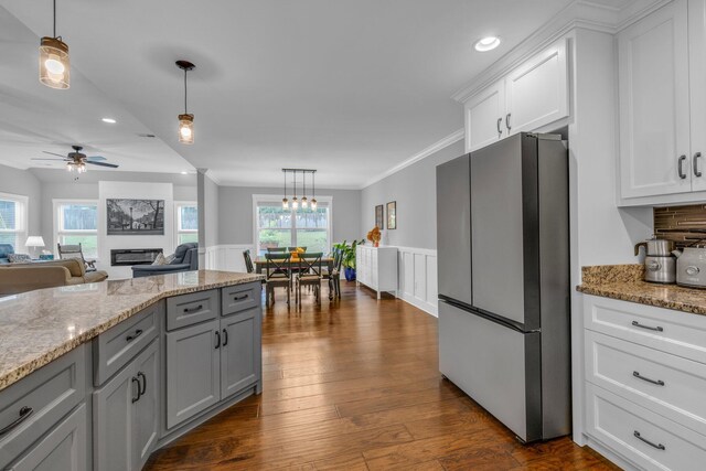 8012 Mcdonald Cemetery Rd, Ooltewah, TN 37363 - kitchen with freestanding refrigerator, wainscoting, white cabinetry, pendant lighting, and ornamental molding
