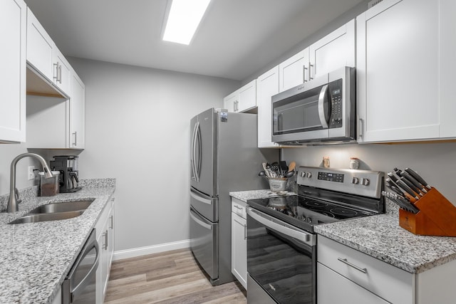 900 Mountain Creek Rd Unit 300, Chattanooga, TN 37405 - kitchen with appliances with stainless steel finishes, a sink, light wood-style flooring, light stone countertops, and white cabinets