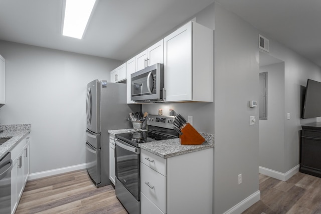 900 Mountain Creek Rd Unit 300, Chattanooga, TN 37405 - kitchen with appliances with stainless steel finishes, light wood-style floors, white cabinets, light stone countertops, and baseboards