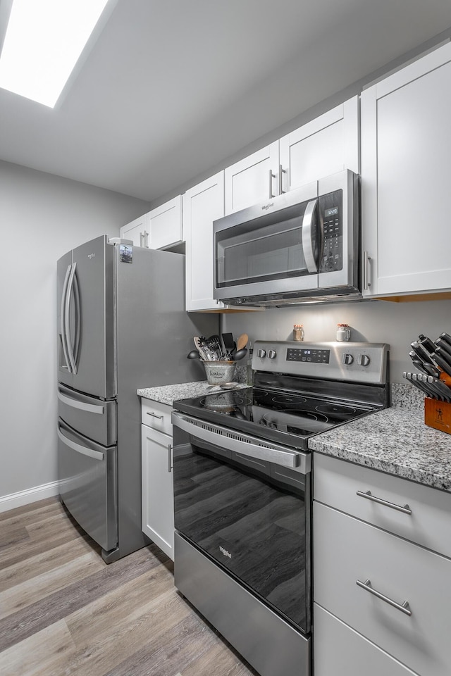900 Mountain Creek Rd Unit 300, Chattanooga, TN 37405 - kitchen featuring stainless steel appliances, light wood finished floors, white cabinets, light stone countertops, and baseboards