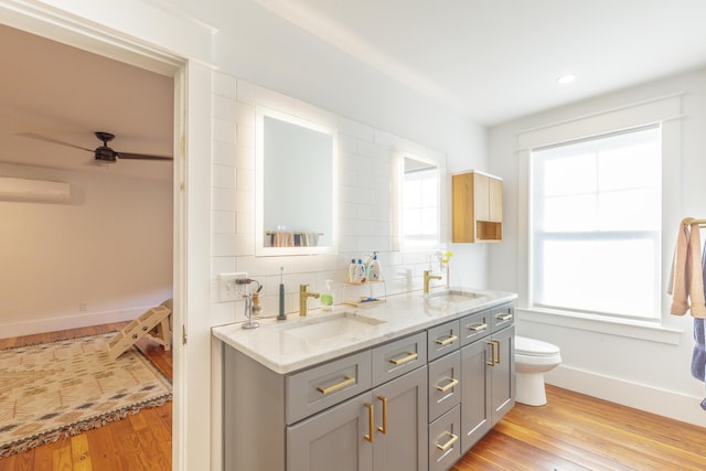 2104 Oak St, Chattanooga, TN 37404 - full bathroom featuring hardwood / wood-style floors, double vanity, toilet, baseboards, and a wall mounted AC
