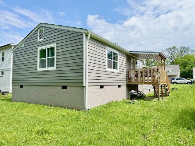 1812 E 13th St, Chattanooga, TN 37404 - view of home's exterior with crawl space, a wooden deck, and a lawn