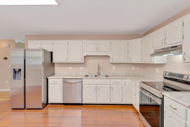 347 Highland Dr, Dunlap, TN 37327 - kitchen with appliances with stainless steel finishes, under cabinet range hood, a sink, white cabinetry, and light wood-type flooring