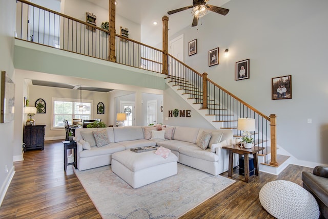 9117 Sir Hudson Ct, Harrison, TN 37341 - living area featuring a towering ceiling, dark wood-type flooring, ceiling fan, stairway, and baseboards