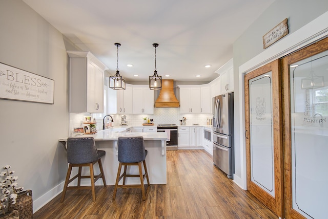 9117 Sir Hudson Ct, Harrison, TN 37341 - kitchen featuring appliances with stainless steel finishes, premium range hood, a peninsula, backsplash, and light countertops