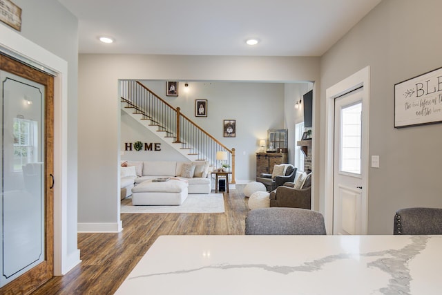 9117 Sir Hudson Ct, Harrison, TN 37341 - living room featuring stairs, dark wood-style flooring, baseboards, a brick fireplace, and recessed lighting