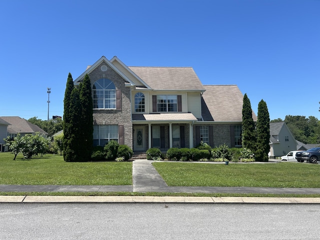 8275 Stillwater Cir, Ooltewah, TN 37363 - traditional home featuring a porch, a front lawn, and brick siding