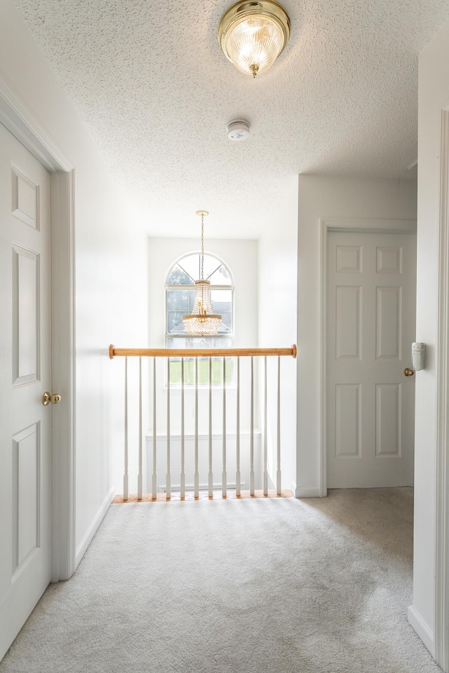 8275 Stillwater Cir, Ooltewah, TN 37363 - corridor featuring carpet, a textured ceiling, a chandelier, and baseboards
