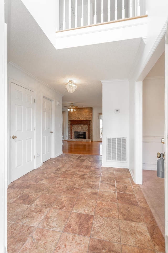 8275 Stillwater Cir, Ooltewah, TN 37363 - unfurnished living room featuring ornamental molding, a ceiling fan, a fireplace, and light stone finish flooring