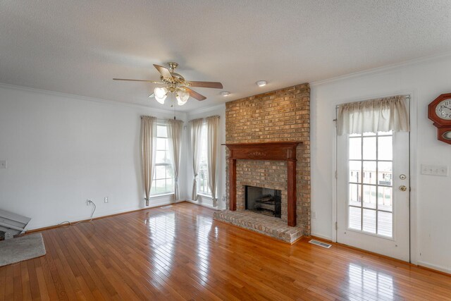 8275 Stillwater Cir, Ooltewah, TN 37363 - unfurnished living room with a ceiling fan, healthy amount of natural light, a fireplace, ornamental molding, and hardwood / wood-style floors