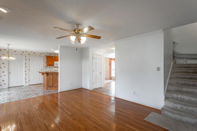 8275 Stillwater Cir, Ooltewah, TN 37363 - unfurnished living room featuring wood-type flooring, stairs, ceiling fan, a chandelier, and baseboards