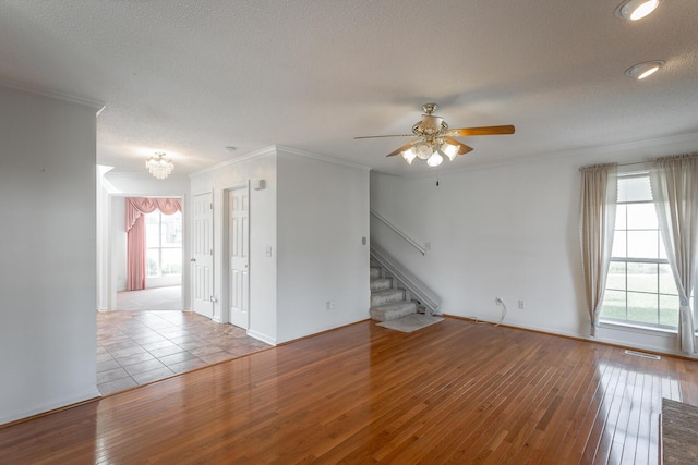 8275 Stillwater Cir, Ooltewah, TN 37363 - unfurnished room with hardwood / wood-style flooring, stairs, ceiling fan, a chandelier, and crown molding