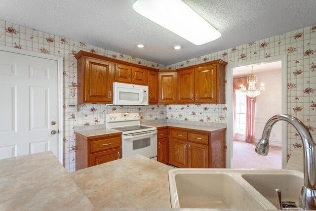 8275 Stillwater Cir, Ooltewah, TN 37363 - kitchen featuring white appliances, wallpapered walls, a sink, a textured ceiling, and light countertops