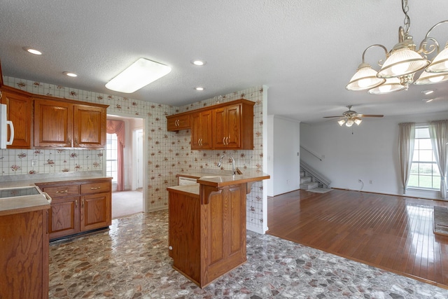 8275 Stillwater Cir, Ooltewah, TN 37363 - kitchen with a textured ceiling, ceiling fan, brown cabinets, open floor plan, and a chandelier