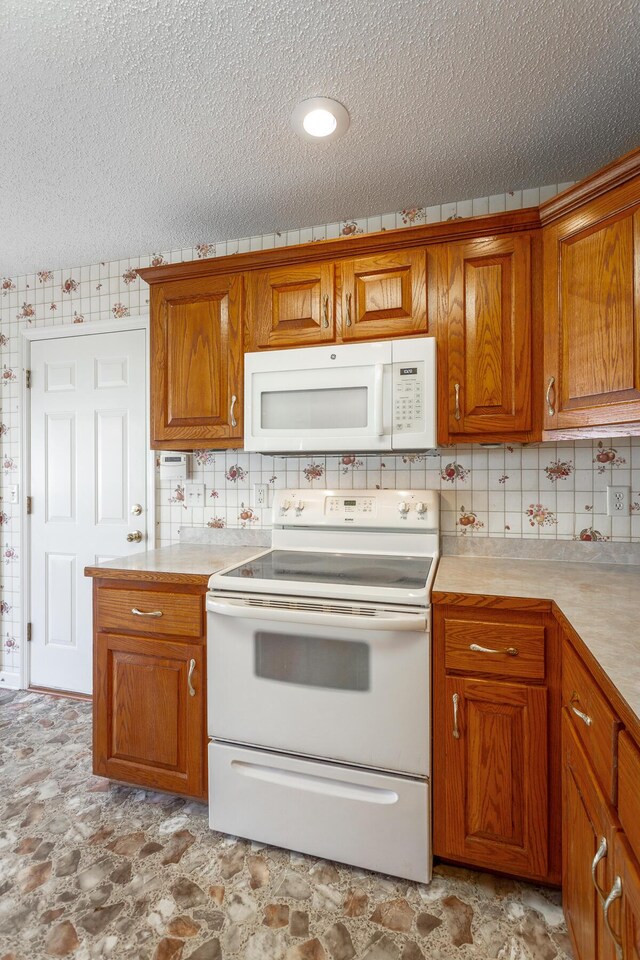 8275 Stillwater Cir, Ooltewah, TN 37363 - kitchen featuring white appliances, brown cabinets, a textured ceiling, and light countertops