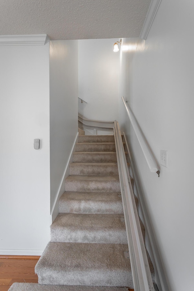 8275 Stillwater Cir, Ooltewah, TN 37363 - staircase with a textured ceiling, wood finished floors, baseboards, and crown molding
