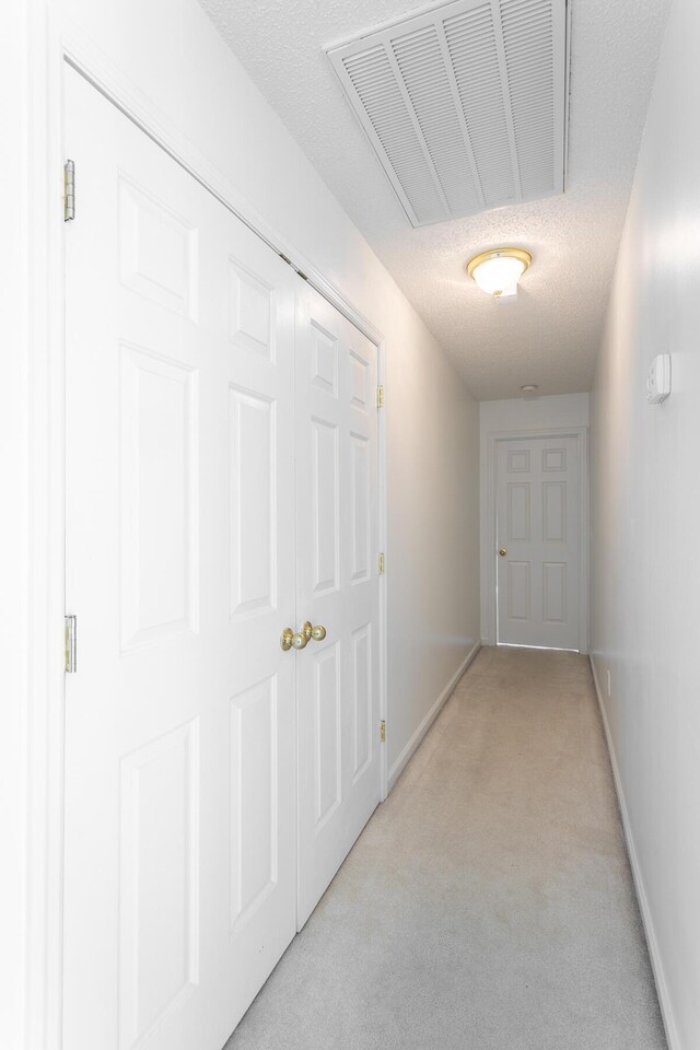 8275 Stillwater Cir, Ooltewah, TN 37363 - hallway featuring light carpet, baseboards, and a textured ceiling