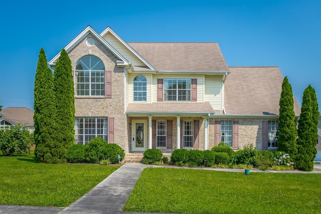 8275 Stillwater Cir, Ooltewah, TN 37363 - view of front facade with a front lawn, covered porch, and brick siding