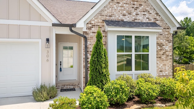 306 Stonegate Way, Soddy Daisy, TN 37379 - property entrance with an attached garage, a shingled roof, board and batten siding, and stone siding