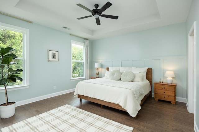306 Stonegate Way, Soddy Daisy, TN 37379 - bedroom featuring a tray ceiling, dark wood-style floors, a ceiling fan, wainscoting, and a decorative wall