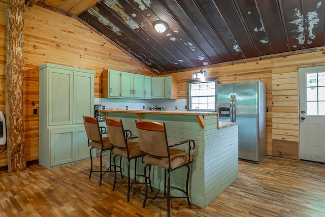 253 Hartline Rd, Trenton, GA 30752 - kitchen featuring stainless steel fridge, green cabinets, wood walls, lofted ceiling, and wood finished floors