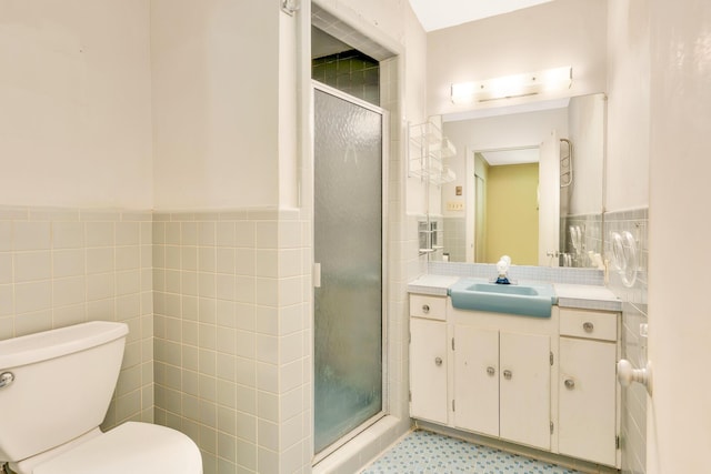 208 Barbara Ln, Chattanooga, TN 37411 - bathroom featuring tile walls, vanity, toilet, a shower stall, and a wainscoted wall