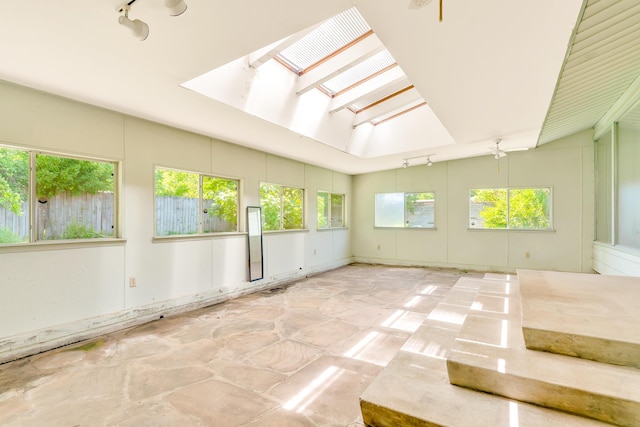 208 Barbara Ln, Chattanooga, TN 37411 - empty room with plenty of natural light, a skylight, vaulted ceiling, and stone finish flooring