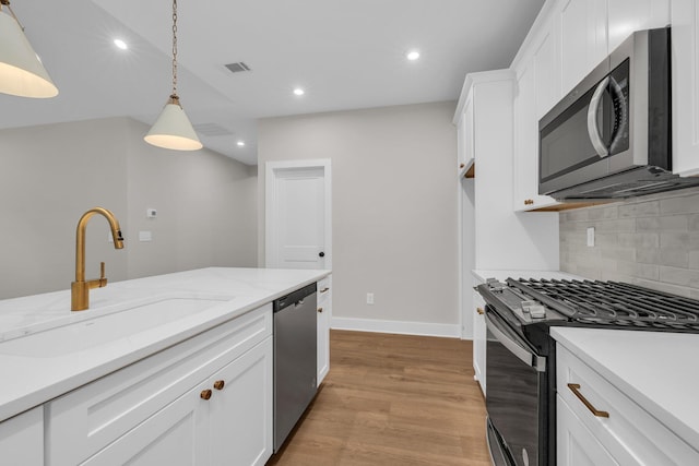 2732 Butlers Green Cir Unit 27, Chattanooga, TN 37421 - kitchen featuring appliances with stainless steel finishes, a sink, light wood-style floors, backsplash, and white cabinetry