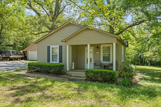 8504 Walnut Rd, Hixson, TN 37343 - bungalow-style home with a porch, driveway, an attached garage, and a front lawn