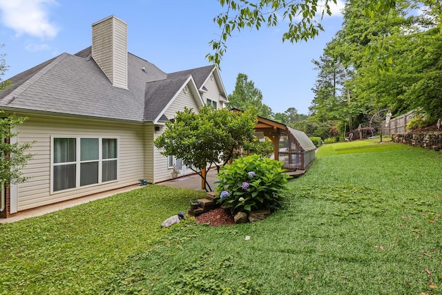 604 Lenna Ln, Dalton, GA 30720 - view of home's exterior with a yard, an exterior structure, a shingled roof, a patio area, and a chimney