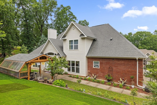 604 Lenna Ln, Dalton, GA 30720 - rear view of house with an exterior structure, brick siding, a chimney, a shingled roof, and a lawn