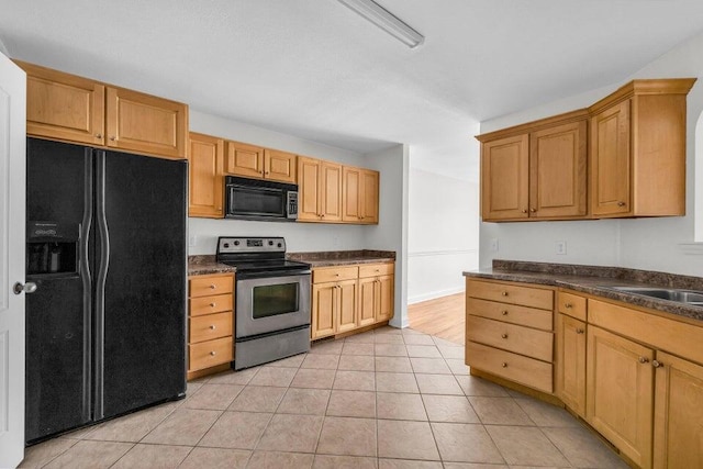 1770 Thrasher Pike, Hixson, TN 37343 - kitchen with black appliances, dark countertops, light tile patterned flooring, a sink, and baseboards