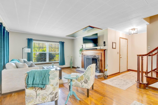 1615 Wilson Rd, Rossville, GA 30741 - living room featuring stairs, a fireplace with raised hearth, wood finished floors, crown molding, and baseboards