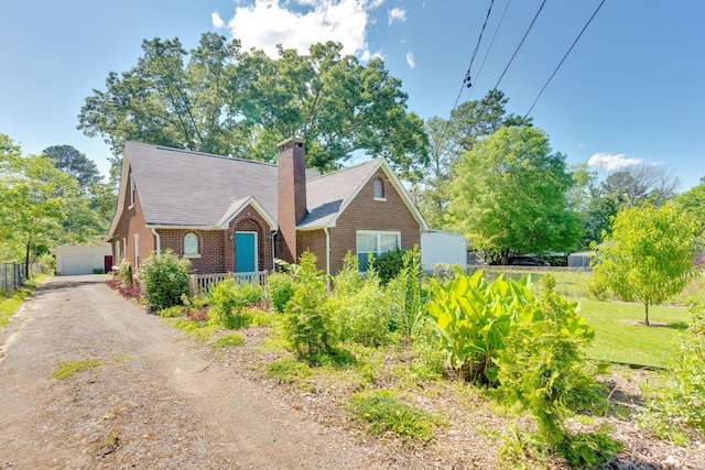 1615 Wilson Rd, Rossville, GA 30741 - view of front of house with brick siding, an outdoor structure, a chimney, and a detached garage