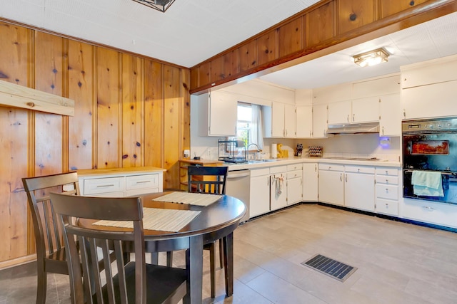 1615 Wilson Rd, Rossville, GA 30741 - kitchen with white appliances, light countertops, under cabinet range hood, wooden walls, and white cabinets