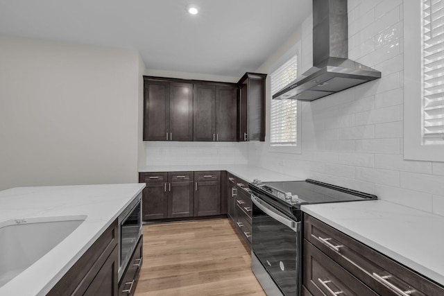 2592 Butlers Green Cir Unit 9, Chattanooga, TN 37421 - kitchen featuring range with electric cooktop, wall chimney exhaust hood, dark brown cabinets, backsplash, and light wood-style flooring