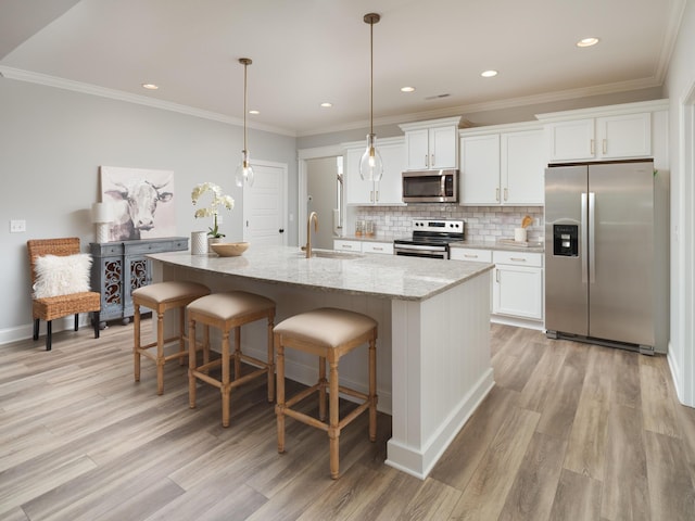 8868 Knolling Loop Unit 36, Ooltewah, TN 37363 - kitchen featuring stainless steel appliances, light wood-style floors, an island with sink, white cabinetry, and tasteful backsplash