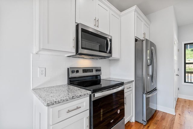 607 Westover Dr SW, Cleveland, TN 37311 - kitchen with appliances with stainless steel finishes, light wood finished floors, backsplash, white cabinetry, and light stone countertops